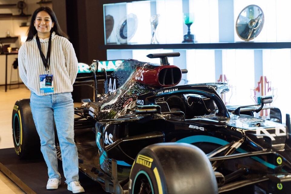 Jess stands in front of Lewis Hamilton's F1 Mercedes car