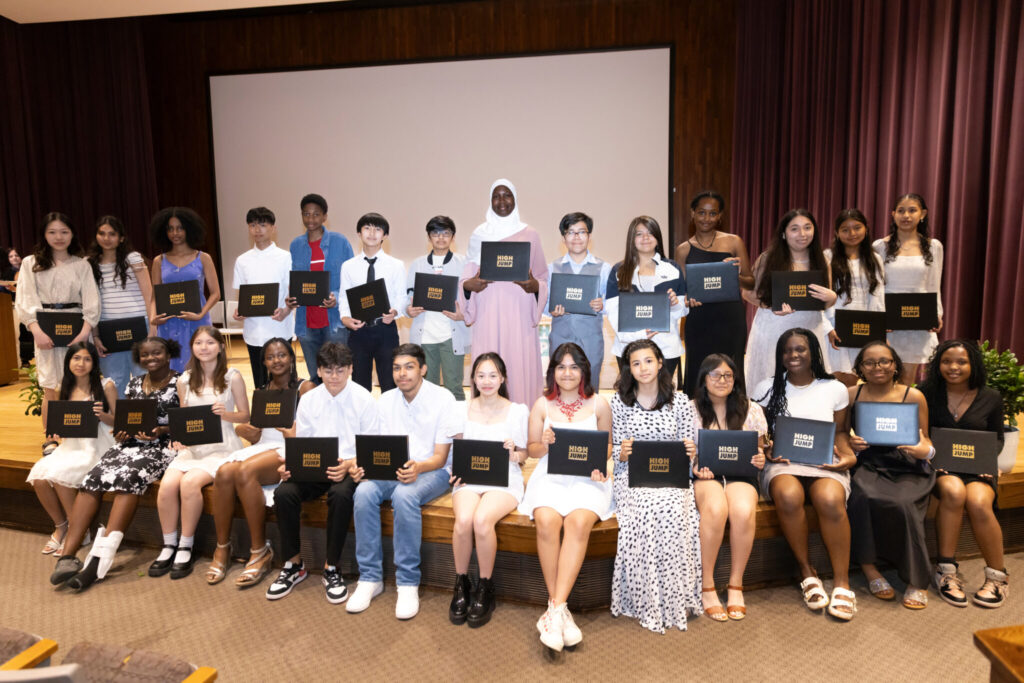Community Scholars graduates stand on the stage with their diplomas