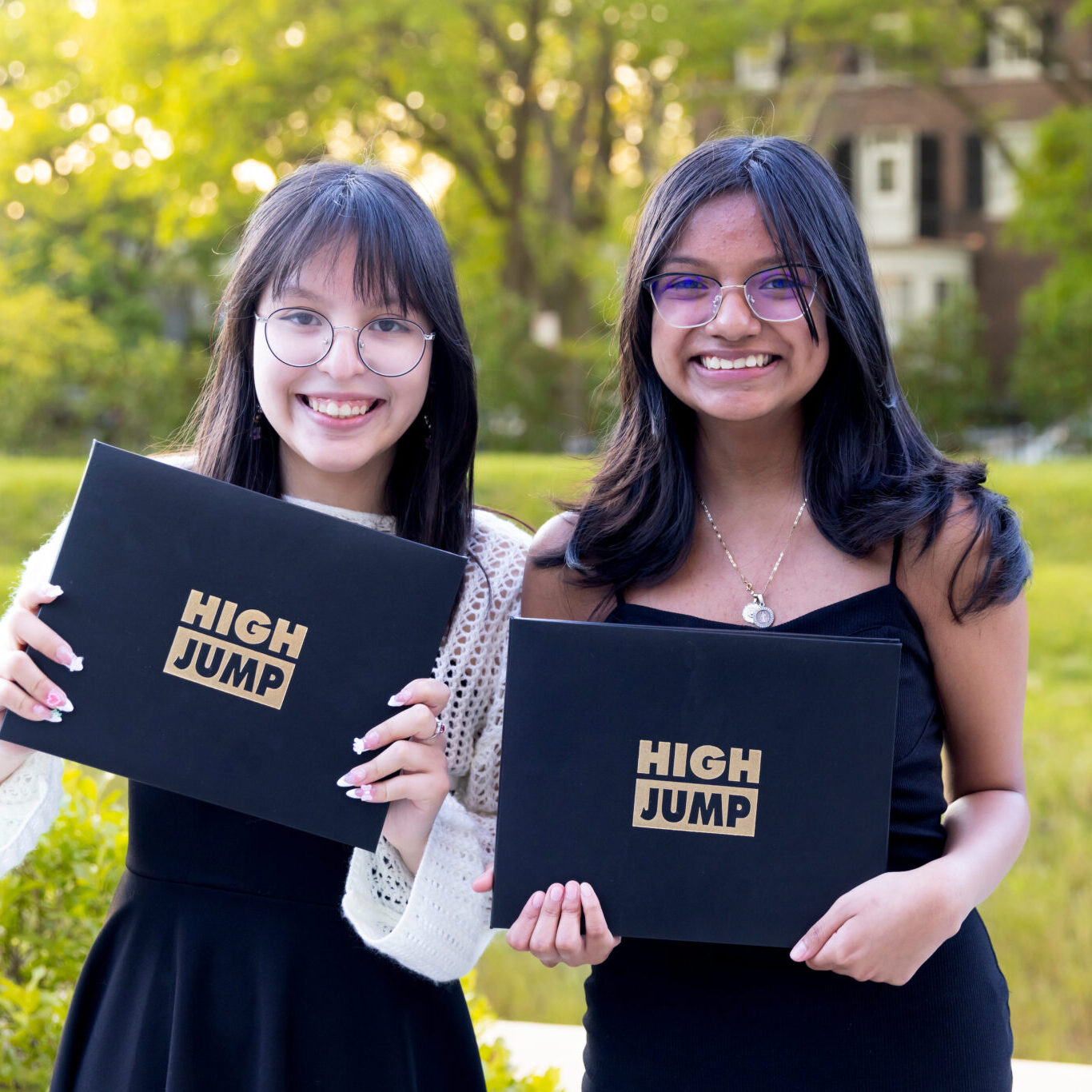 Two high Jump students stand holding their diplomas