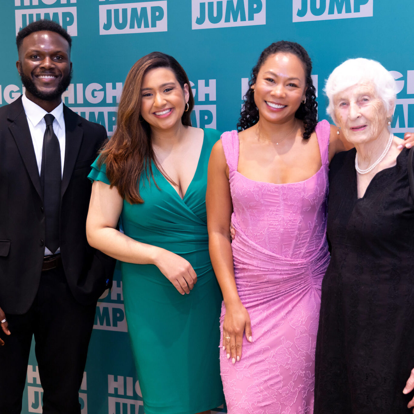 Three High Jump alumni – Richard Mbouombouo, Elaine Rojas-Castillo, and Aris Mendoza – stand with High Jump founder Eleanor Nicholson, dressed in cocktail attire at High Jump's annual benefit.