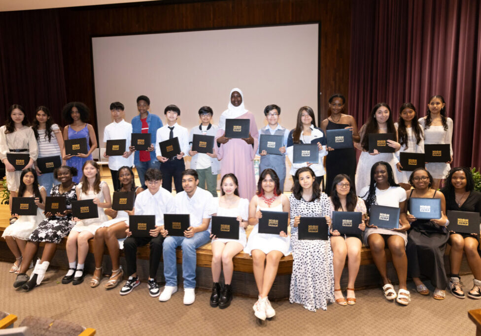 Community Scholars graduates stand on the stage with their diplomas